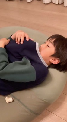 服の上から犬を撫でる男の子