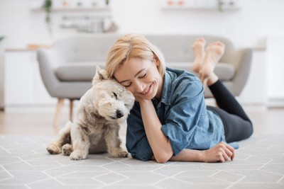 頭をくっつける犬と女性