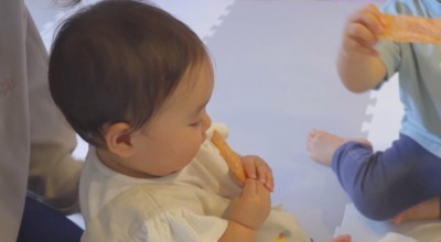 犬用おやつを見つめる赤ちゃん