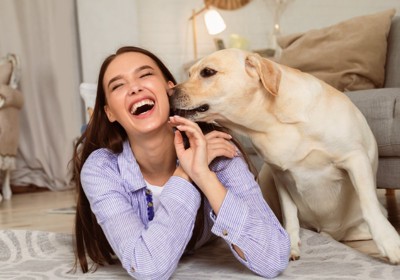 女性の顔を舐める犬