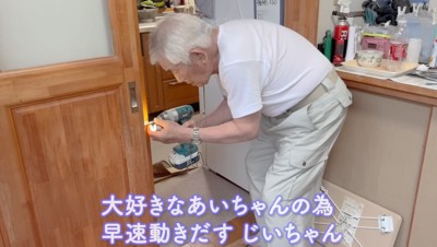 工具を持って壁に穴を開けるおじいちゃん