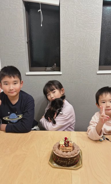 クリスマスケーキの前に並ぶ3人の子どもとチワワ