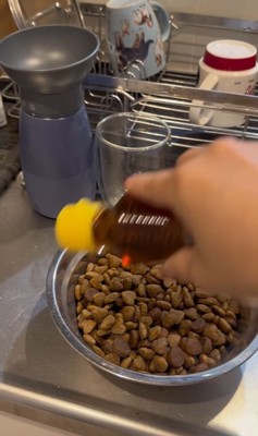 ご飯にごま油をかけるふりをする飼い主