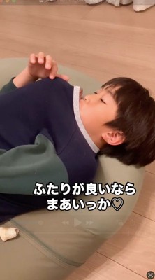 服の上から犬を撫でる男の子と、男の子の顔を舐める犬