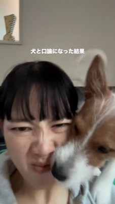 飼い主に顔をくっつけて吠える犬