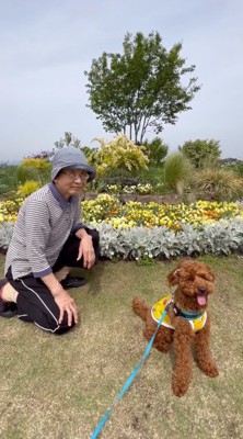 座っている犬の後ろにしゃがむ女性