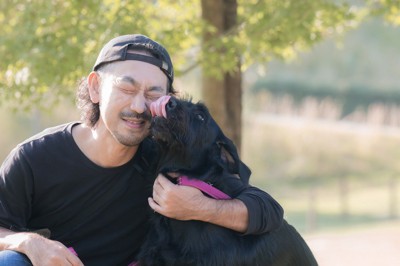 男性の顔を舐める犬