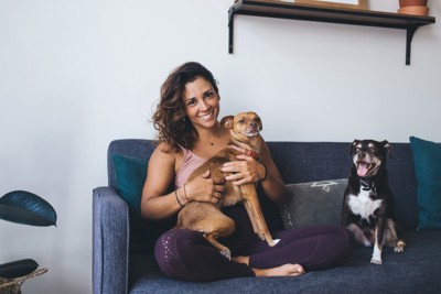 女性の膝の上に乗る犬