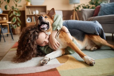 犬を後ろから抱きしめる女性
