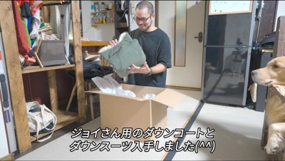 段ボールから犬用の服を取り出す男性