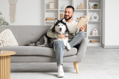 男性にくっついている犬
