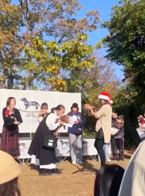 女性から表彰を受け取る飼い主