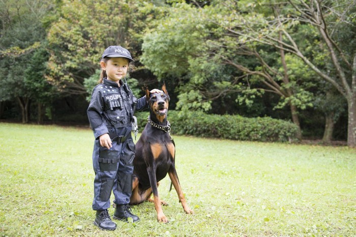 人の子供と並んでいる犬