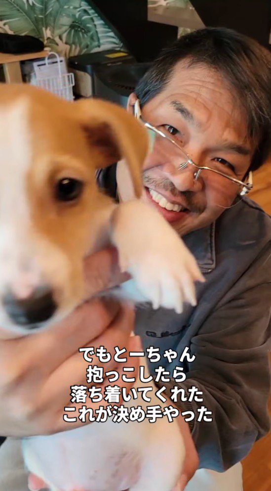 子犬を抱っこして笑顔を見せる男性