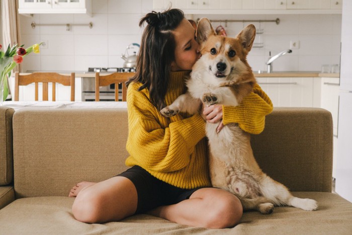 犬を抱きしめてキスする女性