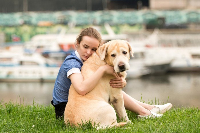 犬をハグして落ち込む女性