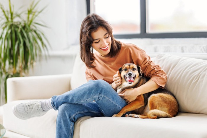 ソファーでくつろぐ女性と犬