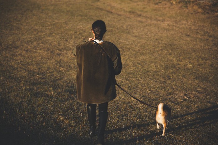 目立たない服装で散歩する人と犬