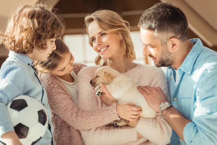 子犬を抱く女性と家族