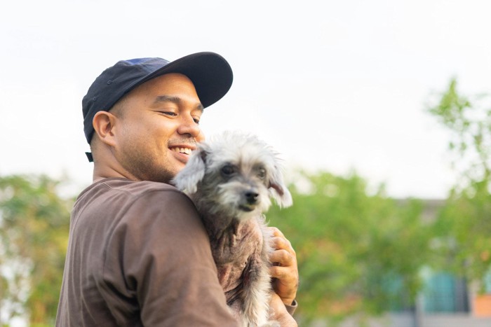 抱きかかえられている犬