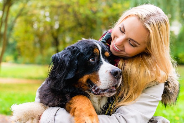 笑顔で犬を抱きしめる女性