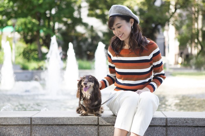 噴水の前の女性と犬