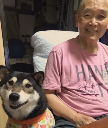 笑顔でカメラ目線のおじいちゃんと黒柴