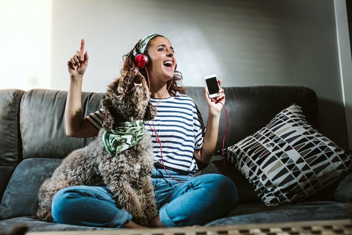 音楽に合わせて歌う女性と犬