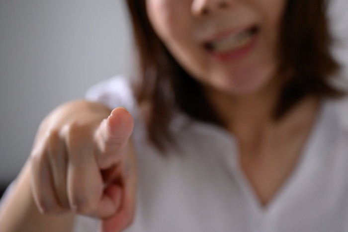 指を差して怒る女性