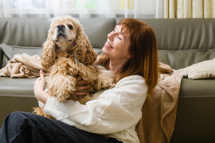 女性にハグされる犬