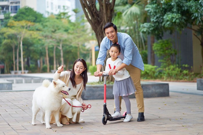 公園で遊ぶ犬連れの家族