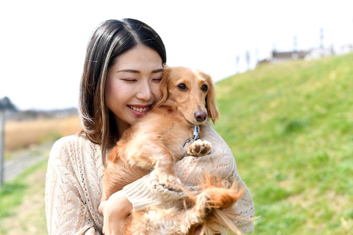 犬を抱っこしている女性