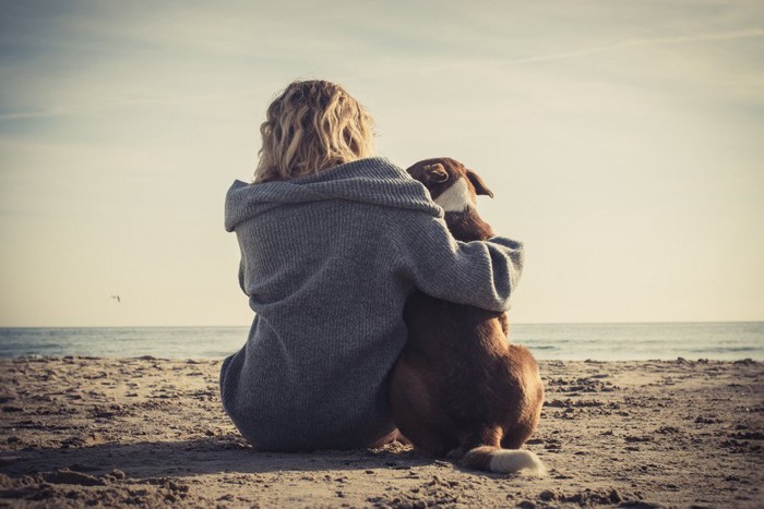 女性と犬の後ろ姿