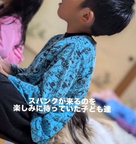 子供の背中にくっついて寝る犬