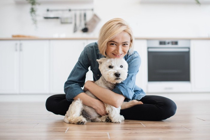 犬を後ろから抱きしめる女性