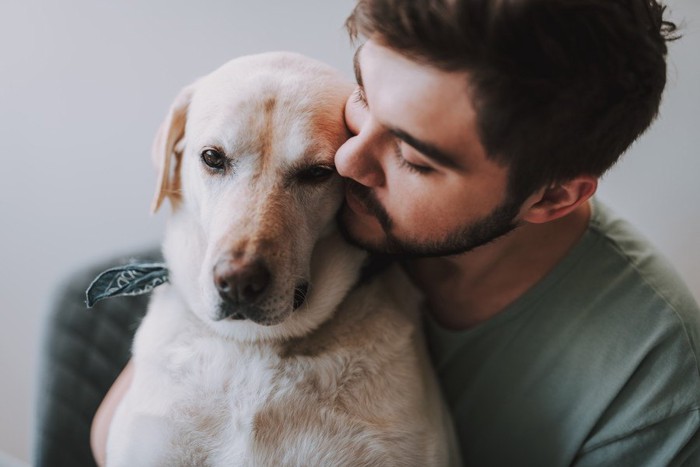 後ろからハグをされる犬