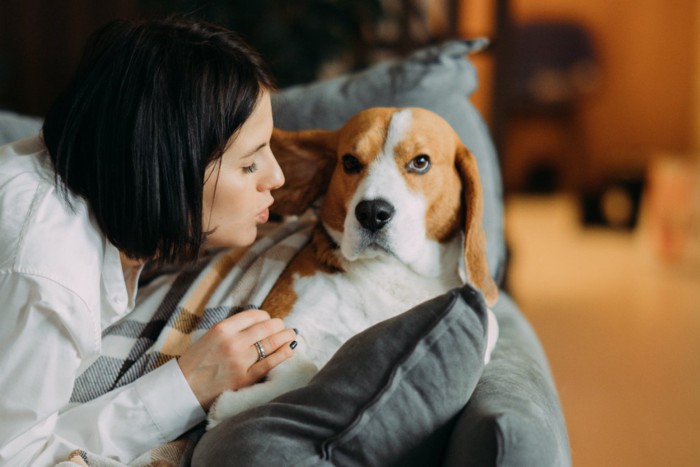 女性と迷惑そうな顔の犬