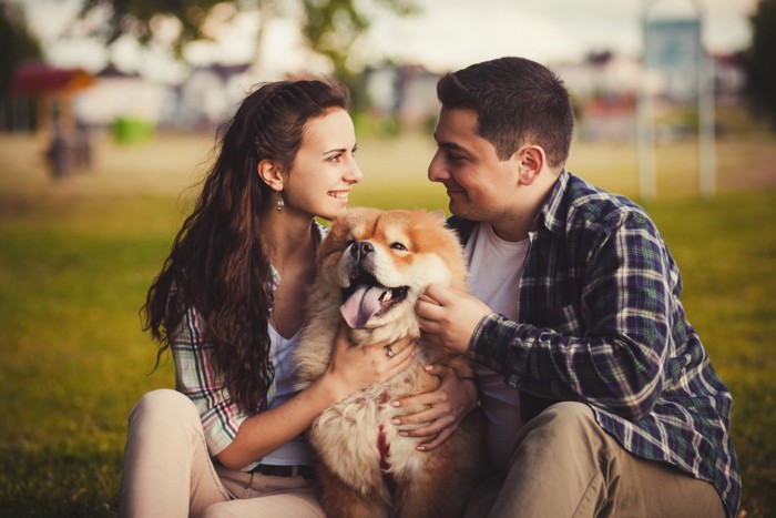 犬を撫でる女性と男性