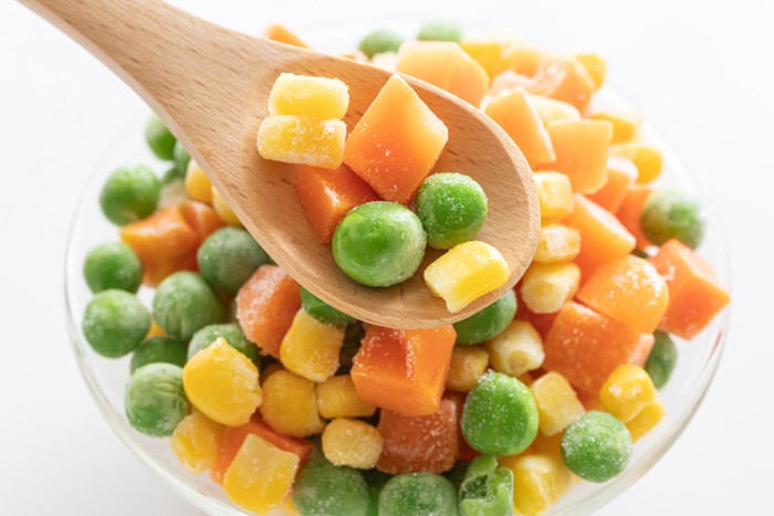 冷凍のミックスベジタブルをスプーンですくっている光景