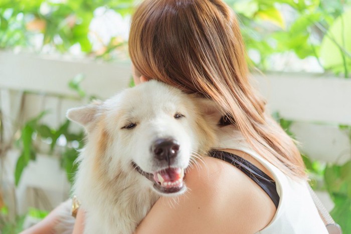 犬を抱きかかえる女性