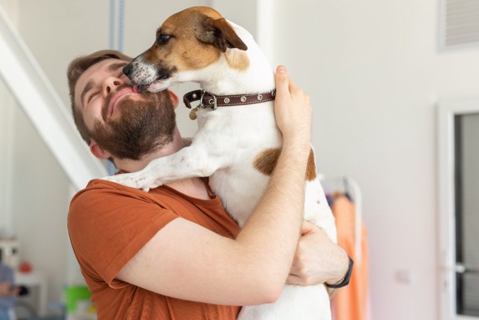 男性の顔を舐める犬