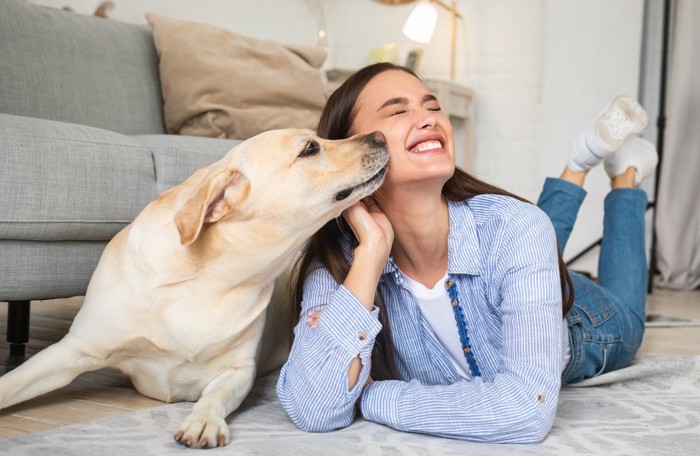 女性の顔を舐めようとする犬