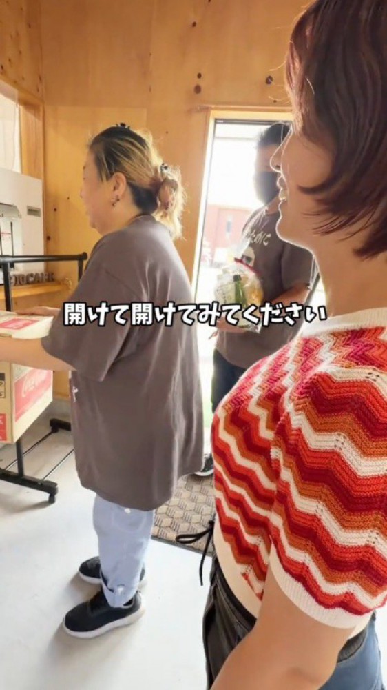 女将にダンボールを差し出す客
