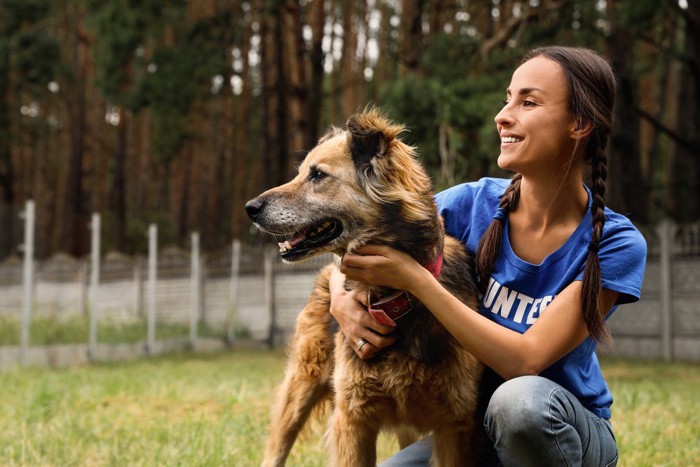 しゃがんでいる女性と犬