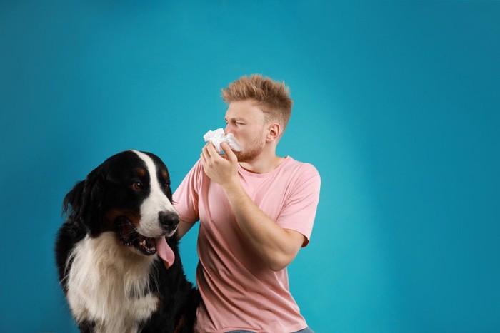 犬と花をかむ男性