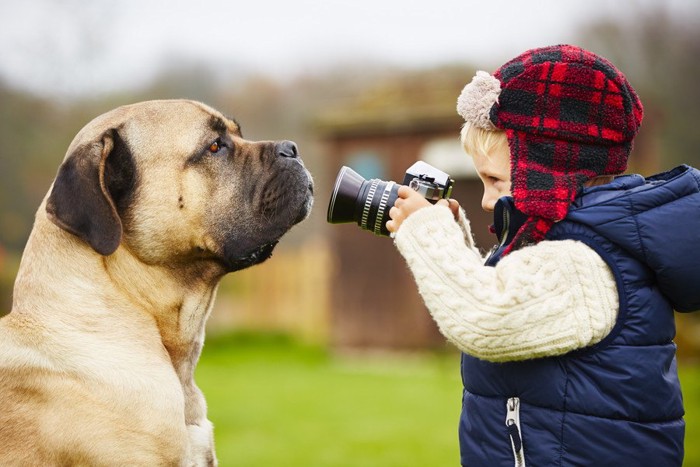 カメラを構える子どもと犬