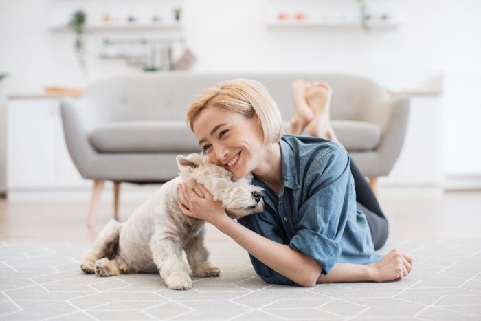 女性と頭を寄せ合う犬