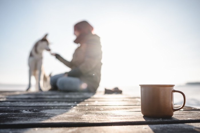 マグカップと犬と女性