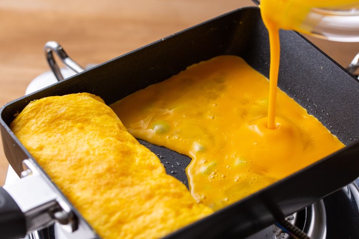 卵焼き器に卵を流し入れている様子