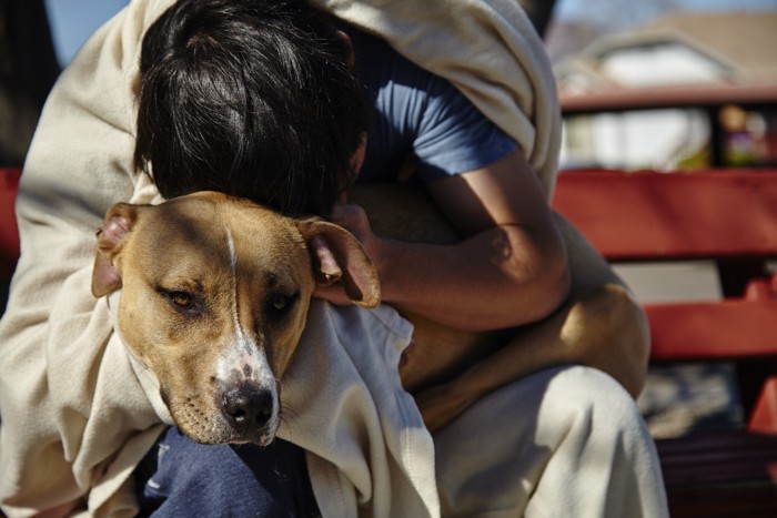 犬を抱きかかえる人